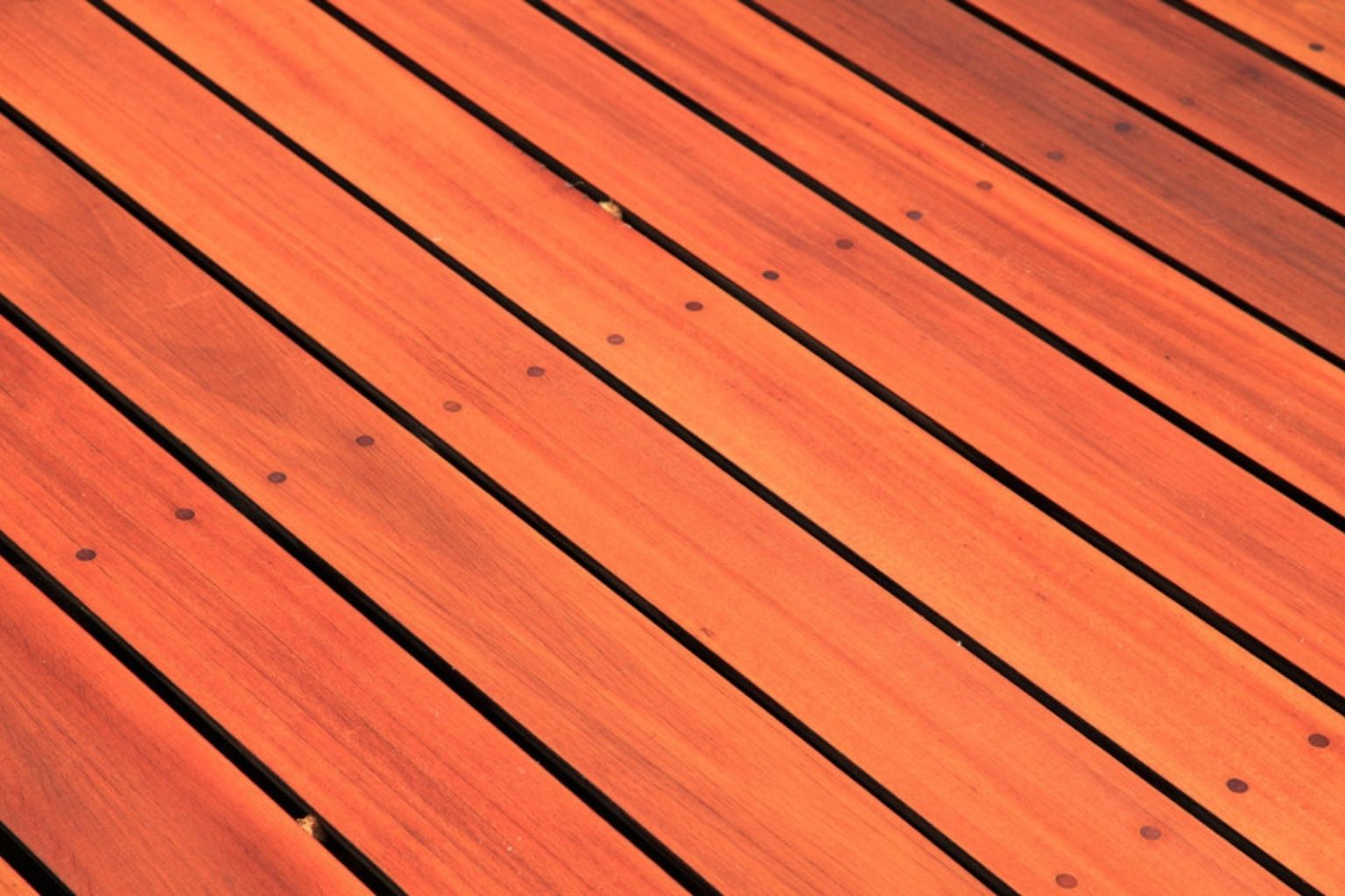 Rødbrune terrassebrædder i hårdttræ lagt diagonalt med jævne fuger